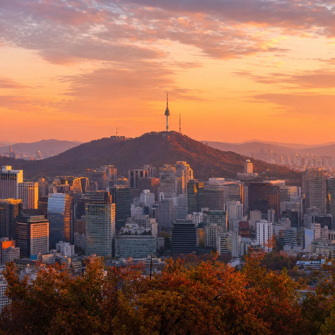 N Seoul Tower on Namsan mountain above the Seoul skyline at golden hour, representing INQUIVIX's Seoul-based operations.